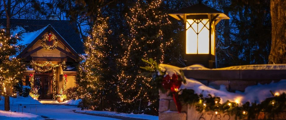 House and trees in Elm Grove, WI, with holiday lights.