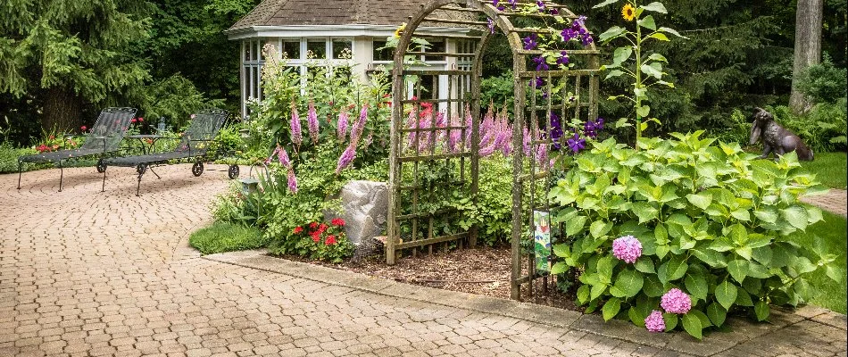 A paver patio with an arbor and plants in Chenequa, WI.